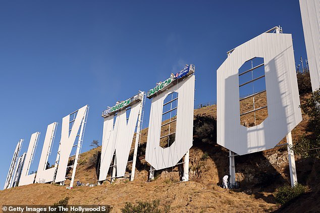 Los Angeles’ famed Hollywood sign gets a new paint job as workers apply 250 gallons of paint