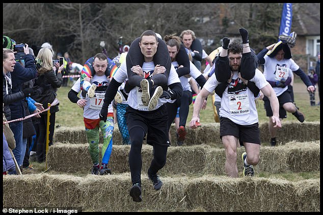 Husbands take part in annual Wife Carrying Race hauling their spouses through 1,200ft course
