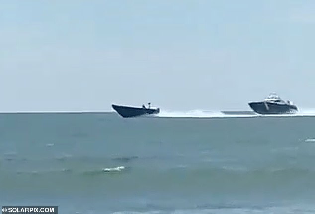 Incredible moment drug smugglers interrupt stunned tourists by beaching their boat and shooting straight past sunbathers to escape the Spanish coastguard