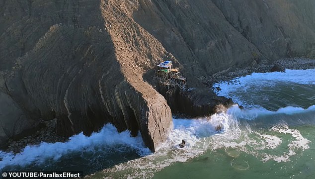 Mysterious house made of driftwood appears perched precariously on side of California cliff just feet above crashing Pacific waves