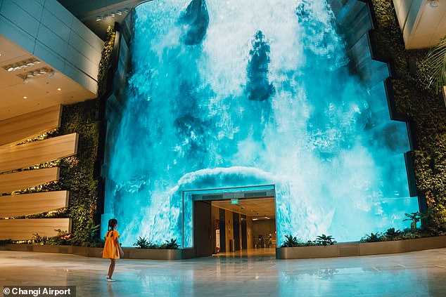 The world’s best airport gets a major makeover, with an incredible 46ft-high digital waterfall and a robot bartender serving free cocktails