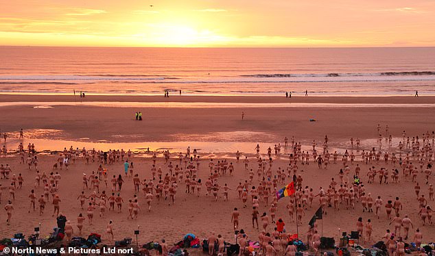 Nude awakening! 1,200 brave skinny dippers dash into the freezing North Sea for charity