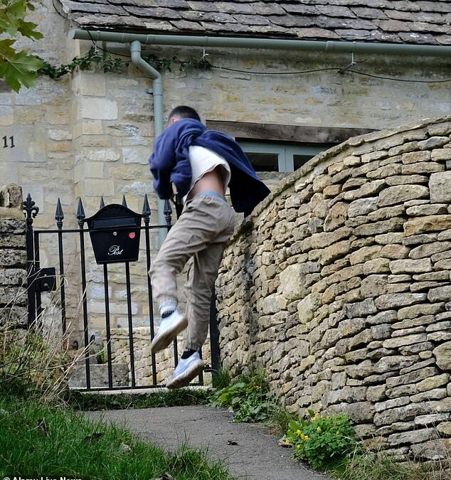 Selfie-hunting tourists jump over garden fences and climb on walls to get the perfect picture in Cotswold village